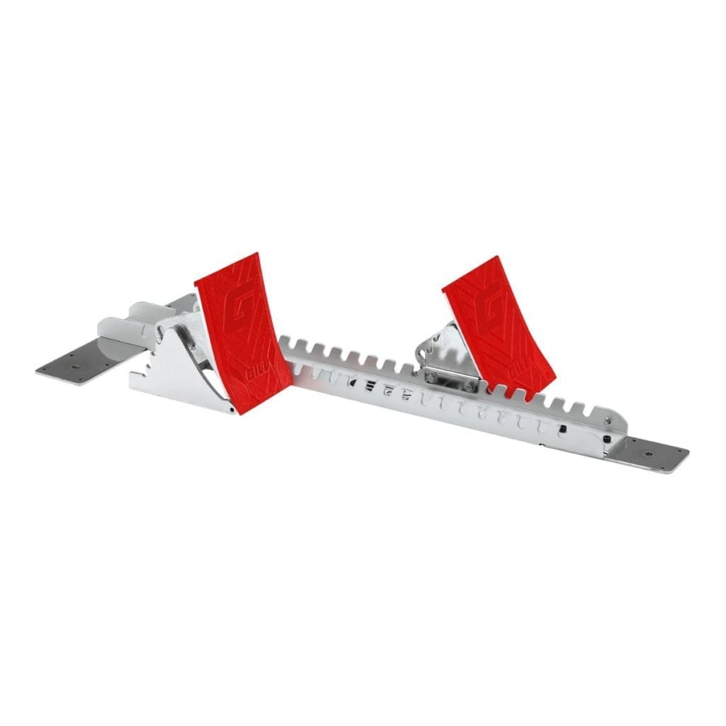 The G2 Starting Block is an adjustable metal sprinting aid for track and field, featuring a ridged base, red pads, and angled footplates for enhanced grip and stability at the start of a race.