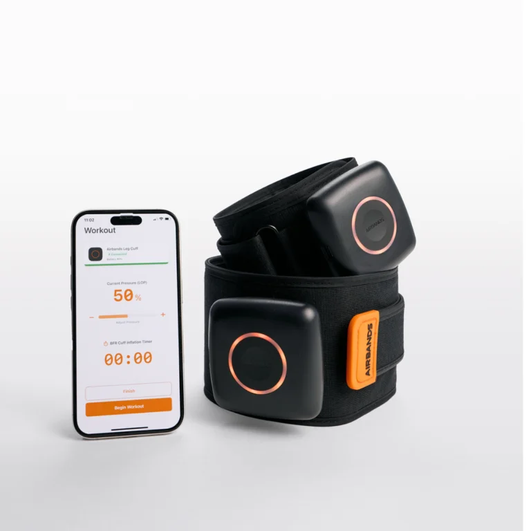 A smartphone with a workout app stands beside AirBands 2.0, a black wearable fitness device featuring orange-accented adjustable straps and square modules.