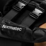 Close-up of a Normatec 3 Lower Body System in black, showcasing adjustable straps and buckles for compression therapy, with the brand name visible on the fabric.