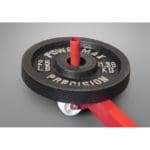 A close-up of a black 25 lb weight plate attached to the PowerMax Vertical Jump Trainers red bar, with white lettering showing the weight in pounds and kilograms, set against a smooth gray background.