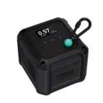 The Vitruve VBT Encoder is a black, cube-shaped device featuring a digital numeric display, a green button, a top-corner black carabiner, and the "VITRUVE" brand name printed on its side.