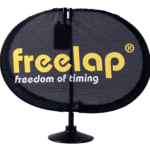 A black, oval-shaped Freelap SpaceUnit features a small stand and the freelap logo in yellow, with freedom of timing displayed below.