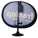 The Freelap SpaceUnit and Power Unit features a circular mesh reflector with FreeLAP branding, mounted on a vertical stand, and includes an electronic device at the center rod. The reflector is trimmed in black.
