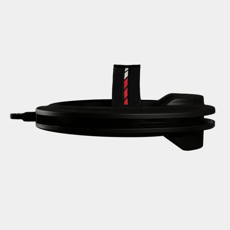 Side view of the Iron Neck 3.0: a black, round object with a handle featuring a black strap adorned with red and white stripes, set against a plain gray background.