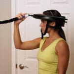 Female athlete demonstrating Iron Neck head gear.