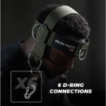 A person wearing the Iron Neck Alpha Harness with six D-ring connections is photographed against a dark background. The text reads 6 D-Ring Connections.