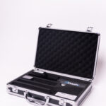 An open silver metal briefcase with a foam-lined interior displays a Dashr Jump Mat and Controller, featuring a black and blue Dashr-branded card and small electronic device, resting on a white surface.