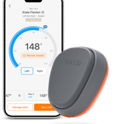 A smartphone displays a knee flexion test app showing a 148-degree angle. Next to it is the compact, gray and orange VALD Dynamo Lit device, used for measuring movement or range of motion.
