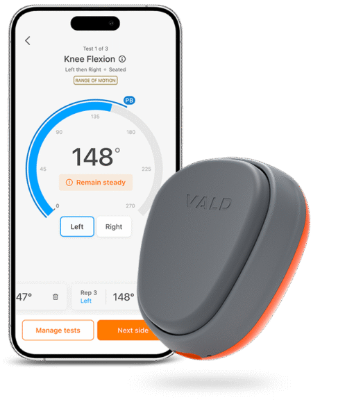 A smartphone displays a knee flexion test app showing a 148-degree angle. Next to it is the compact, gray and orange VALD Dynamo Lit device, used for measuring movement or range of motion.