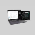 A laptop and a tablet on a gray surface display the GymAware Cloud Subscription: the laptop shows a spreadsheet, while the tablet features a dark dashboard with charts and data visualizations.
