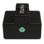The Rapid Remote Release is a black rectangular electronic device featuring a metal connector on top and a circular button with a glowing green ring on the front, shown against a white background.