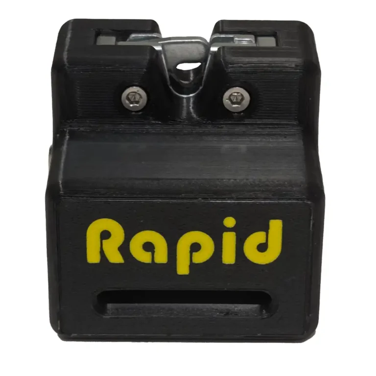 A black and yellow Rapid Remote Release pencil sharpener with "Rapid" in yellow on the front, featuring a metal blade at the top and a pencil slot.