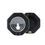 The Sportreact Lab Kit | X6 is a black octagonal device with a transparent circular lens featuring white concentric markings on the front, shown with its open back panel exposing internal electronic contacts.