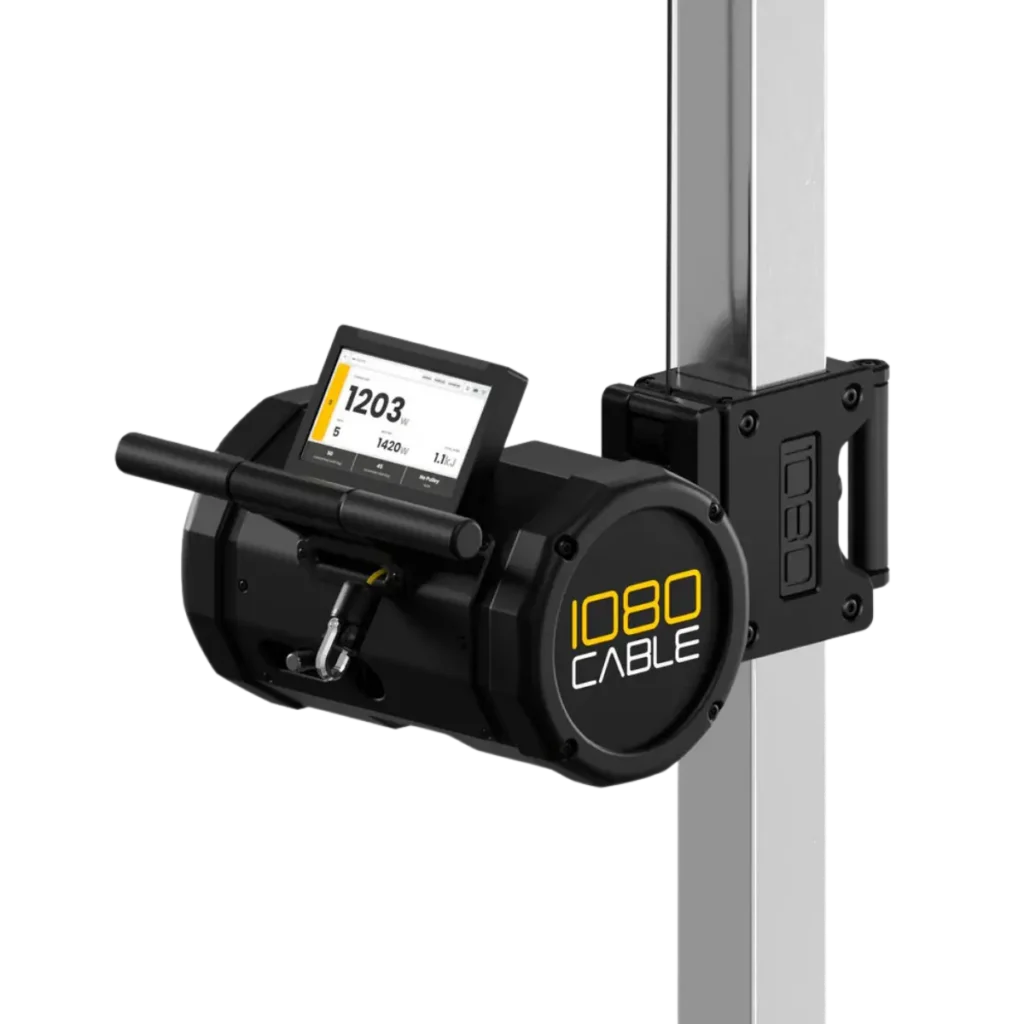 A black 1080 Cable is mounted on a vertical metal pole, featuring a digital display with workout data, a handle, and a cable attachment point.