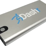 A silver rectangular Dashr Silver 2-Gate System power bank features Dashr and a blue running figure logo, with a round power button and multiple USB ports on the side.