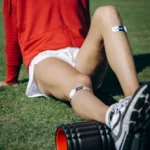Athlete training with calf roller while wearing Firefly Recovery Devices.
