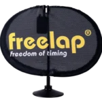 A black, oval-shaped Freelap SpaceUnit features a small stand and the freelap logo in yellow, with freedom of timing displayed below.