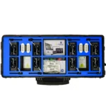 The GymAware 8 Unit Kit is a black and blue storage case filled with electronic components like batteries, circuit boards, labeled buttons, and instruction manuals. Its interior features compartment dividers to neatly organize the items.