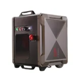 The TAPEX is a portable, rugged electronic device in black and gray with control knobs, buttons, a top handle, bottom wheels, and the TAPEX brand name on its side.