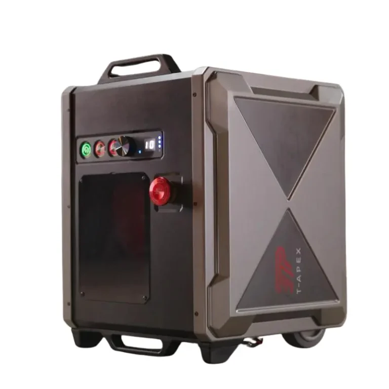 The TAPEX is a portable, rugged electronic device in black and gray with control knobs, buttons, a top handle, bottom wheels, and the TAPEX brand name on its side.