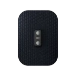 Close-up of the Venom Go, a textured black rectangular device with rounded edges. Designed as a heat and vibration wearable, it features a subtle diagonal pattern, two centered round buttons, and a dotted grid pattern between them indicating a high-tech interface.