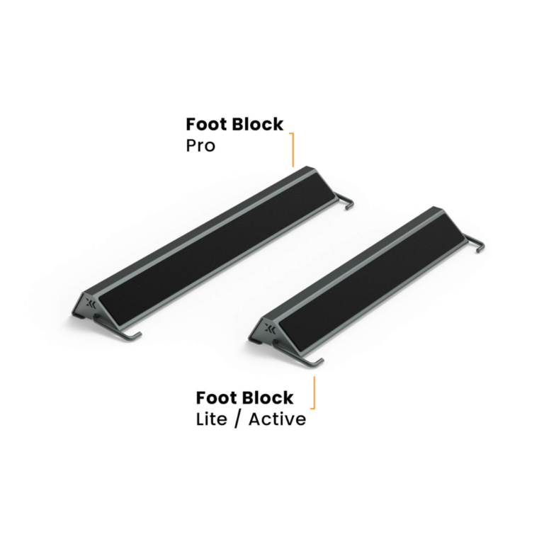 Two black foot blocks with metal ends from the kBox Advanced System are shown; the larger block is labeled Foot Block Pro and the smaller one is labeled Foot Block Lite / Active.