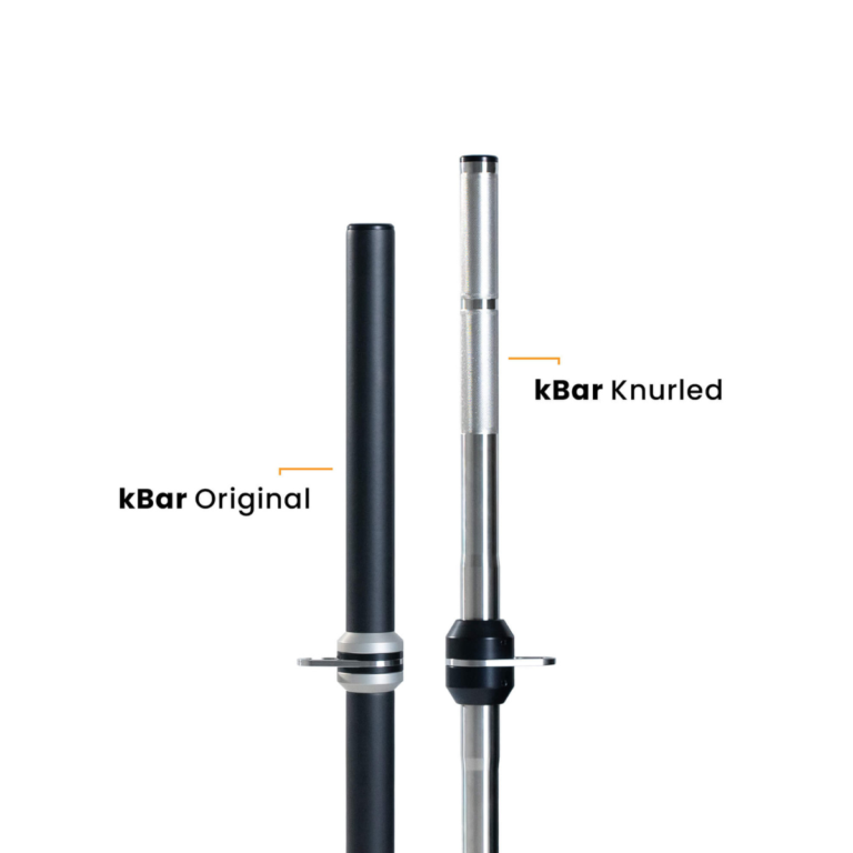 Two vertical workout bars for the kBox Core System are shown: the left, smooth and black, is the kBar Original; the right, silver with a textured knurled grip at the top, is the kBar Knurled.